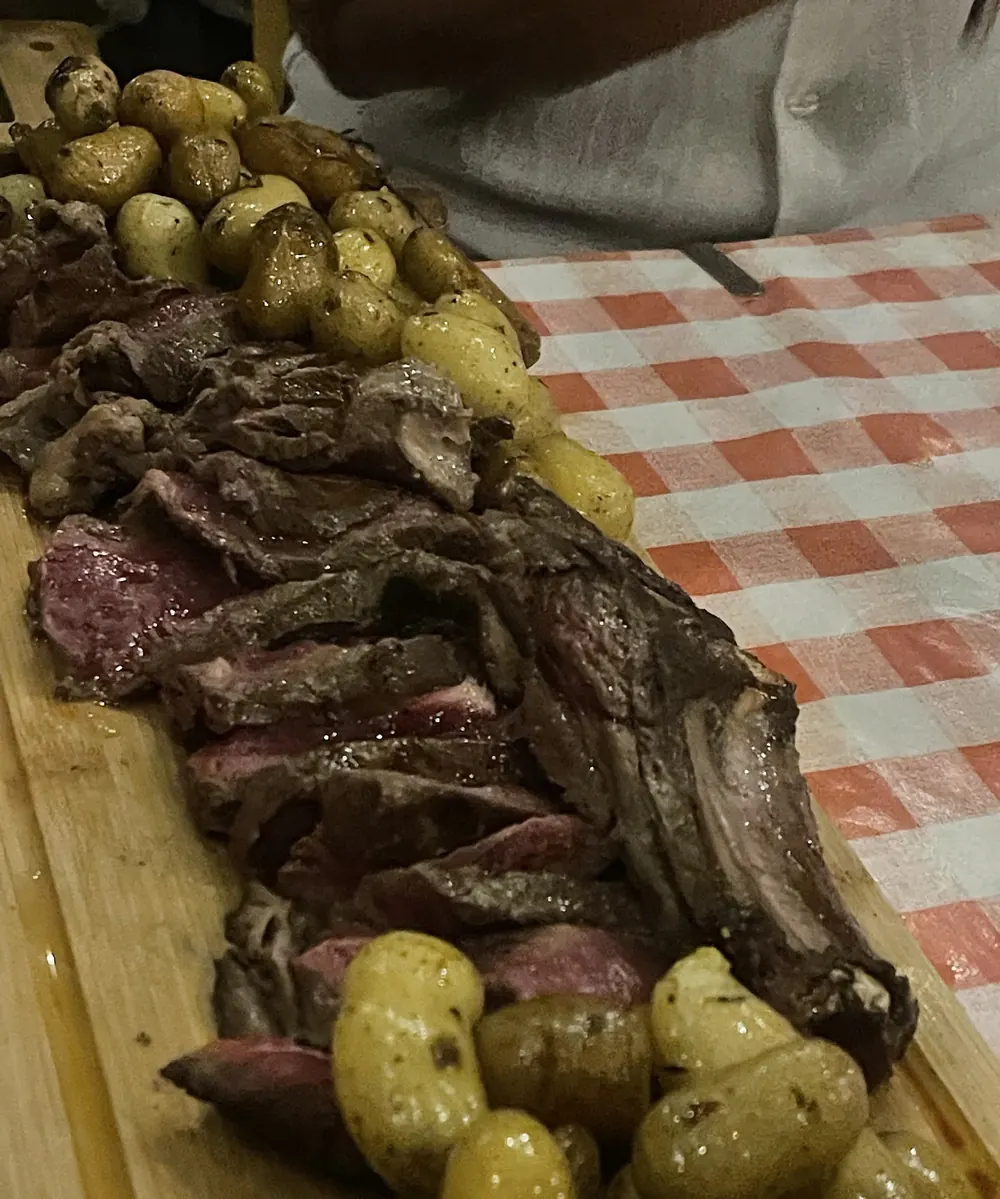 Côte de bœuf tranchée sur planche avec pommes grenaille